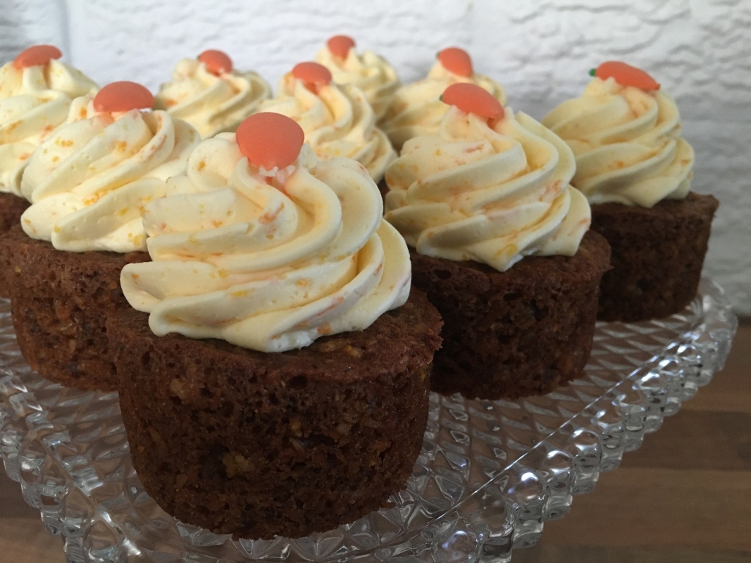 carrot-orange-mini-cakes-with-orange-buttercream-and-edible-carrot-decoration-on-cake-stand-january-2021.jpg